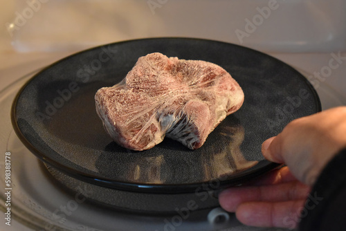 Frozen beef with plastic wrap or cling film defrosted in the microwave.  