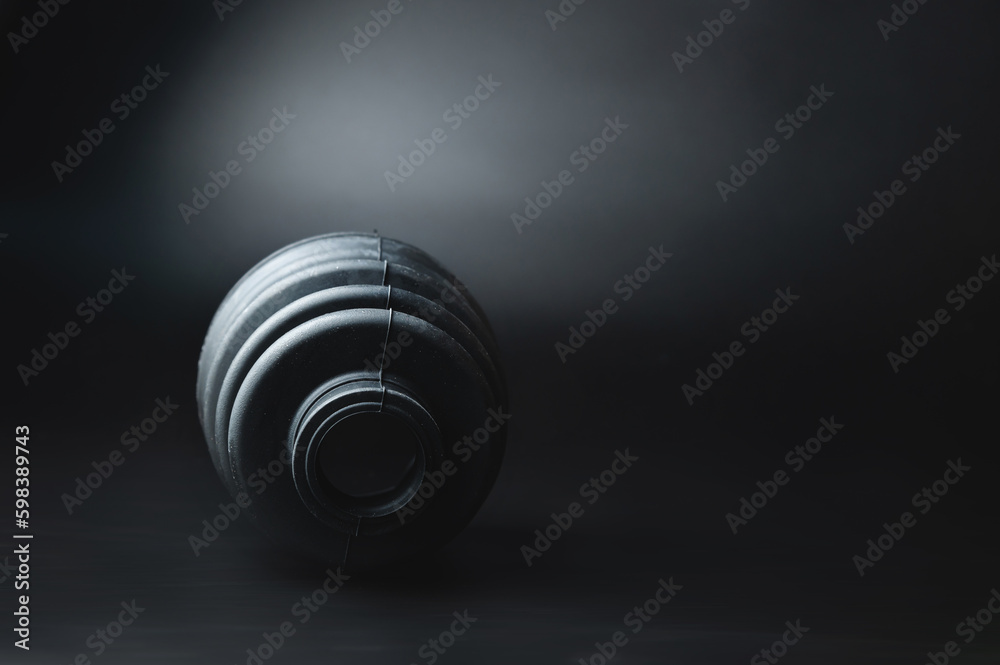 Car CV joint boot on black background. Black rubber drive shaft cover. Constant velocity joint boot isolated. Quality spare parts for car service or maintenance Car CV joint boot on black background. Black rubber drive shaft cover. Constant velocity joint boot isolated. Quality spare parts for car service or maintenance