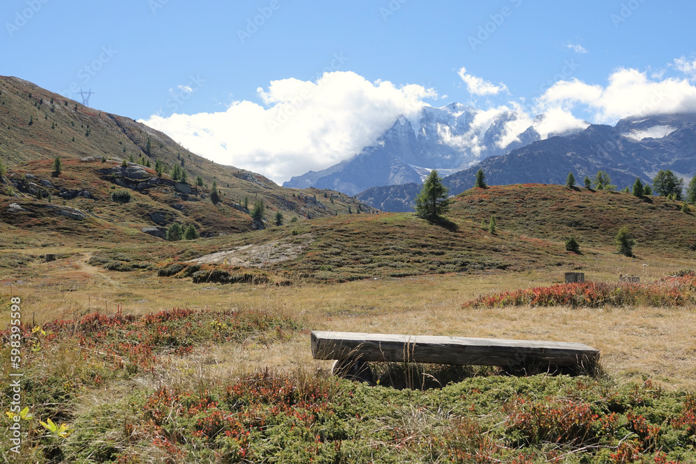 Wooden bench overlooking the mountains surrounding the Simplon Pass between Italy and Switzerland Wooden bench overlooking the mountains surrounding the Simplon Pass between Italy and Switzerland