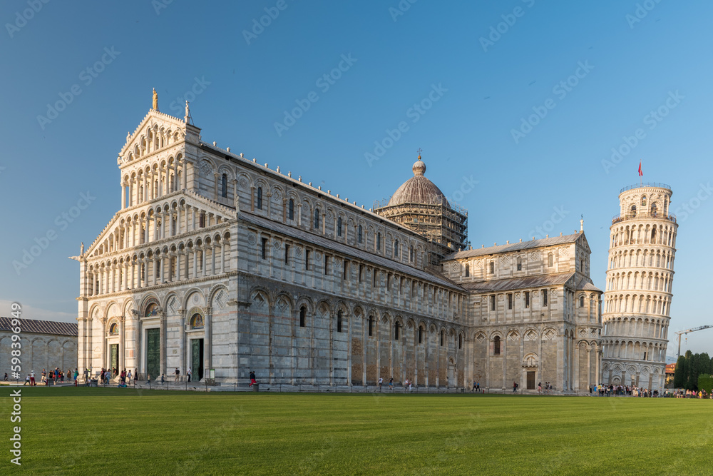 The cathedral of Pisa and the leaning tower in the background during the afternoon. Tuscany, Italy