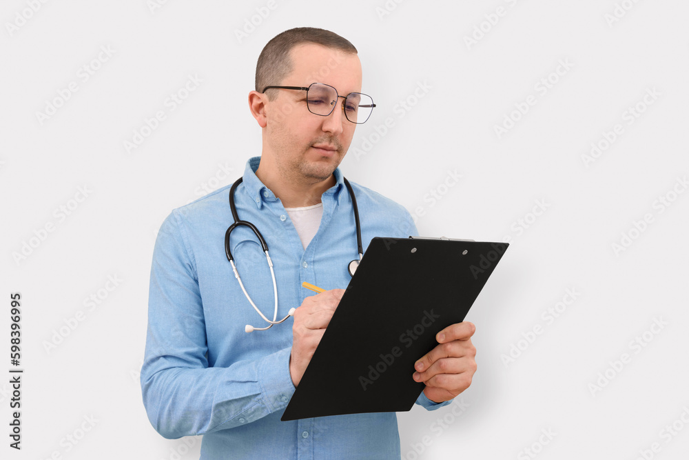 Male doctor with a clipboard in his hands on a white background. Health care and medicine Male doctor with a clipboard in his hands on a white background. Health care and medicine