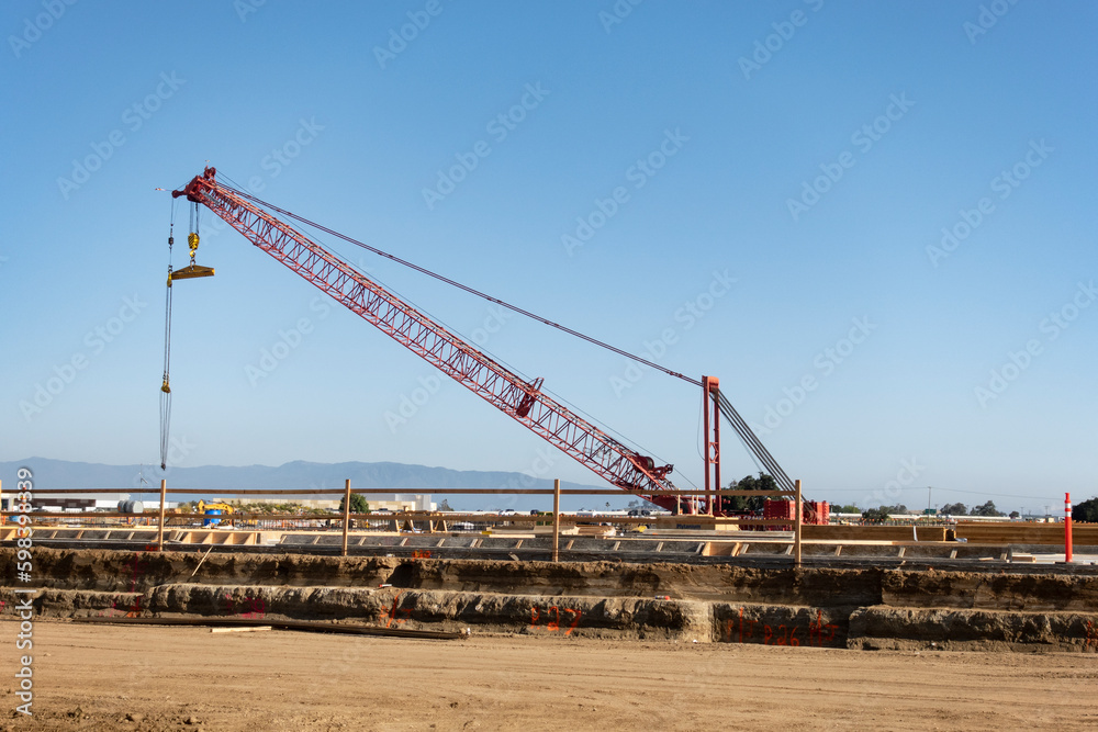Mobile crane at construction site against blue sky.
