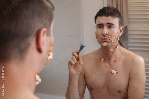Humorous image of clumsy man shaving his beard  photo