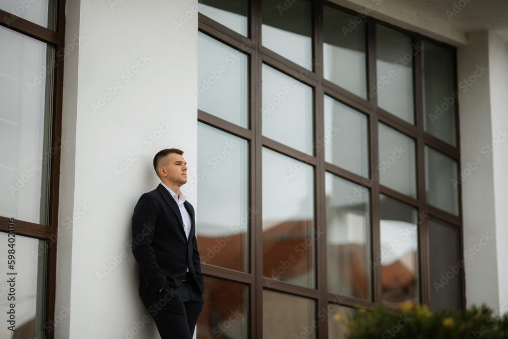portrait of a young guy groom in a dark wool suit portrait of a young guy groom in a dark wool suit