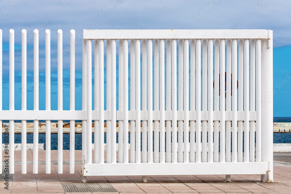 Bars of a white fence against the blue sky Bars of a white fence against the blue sky