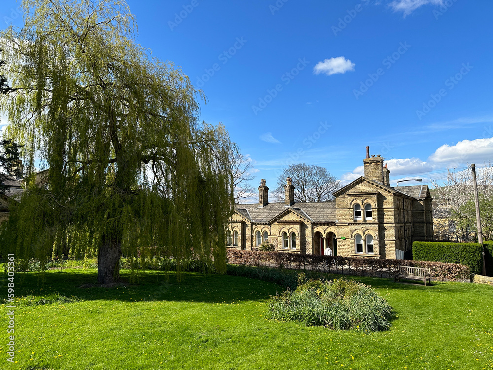 Looking over a green space, with trees, and Victorian cottages, in the World Heritage Site of, Saltaire, Bradford, UK