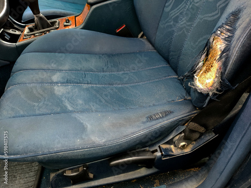 blue car seat with torn upholstery, from long use photo