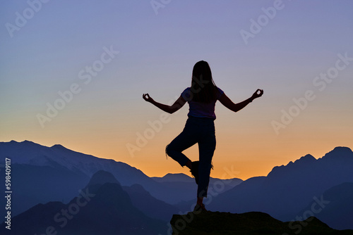 Wallpaper Mural Back of silhouette of girl during meditation training on the top of a mountain hill at sunset. Calm getaway retreat for healthy mind Torontodigital.ca