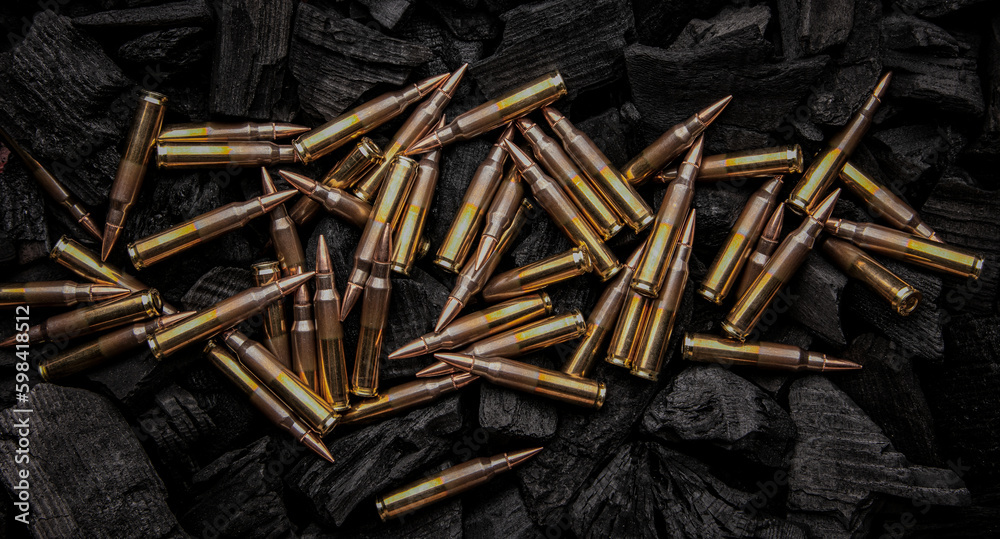 Cartridges for automatic carbine caliber .223 on charcoal. Ammunition for automatic and semi-automatic rifles. Dark back. Cartridges for automatic carbine caliber .223 on charcoal. Ammunition for automatic and semi-automatic rifles. Dark back.
