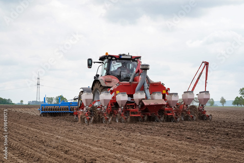 Modernes Maislegen - Traktor mit Lanmaschinen - vorne wird der Boden gelockert, hinten legt die Drillmaschine den Mais. photo