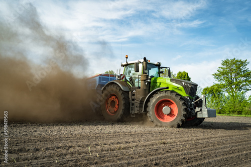 Trecker und Maislegemaschine verschwinden schon fast auf den Acker  so staubt es beim Maislegen.