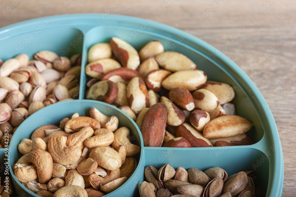Mix of nuts in a container on a wooden table