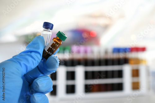 Lab tech holding LCMS testing vials in a laboratory for drug testing photo