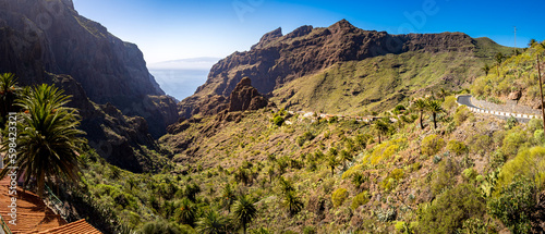 TF-436 mountain road through the Barranco de Masca gorge with the charming Masca village and the imposing Roque de Catana mountain, all framed against the breathtaking backdrop of the Atlantic Ocean.