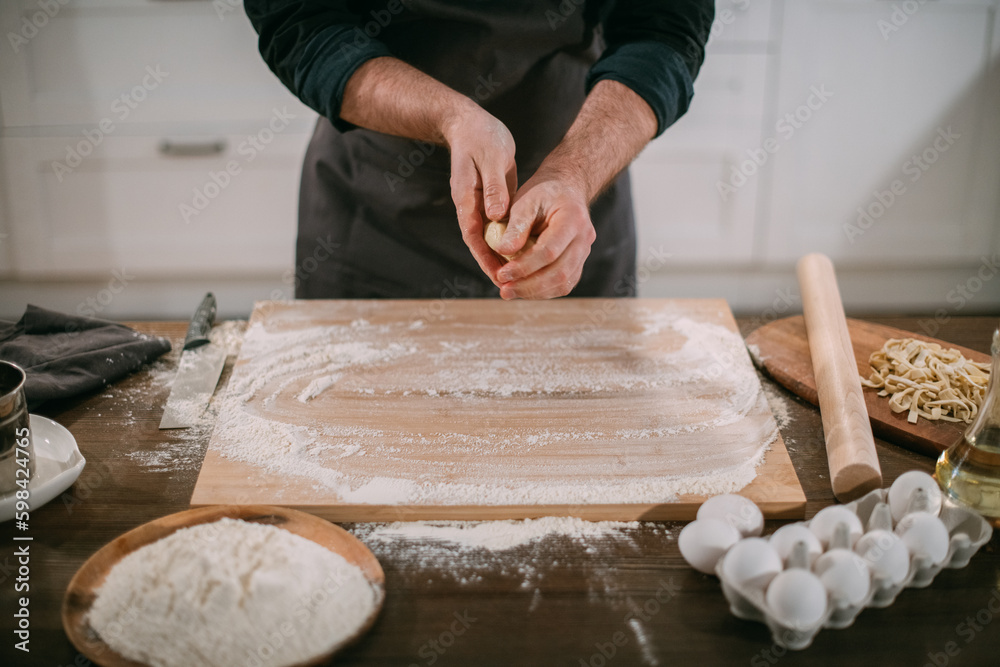 A male chef prepares noodles at home in the kitchen. A male chef prepares noodles at home in the kitchen.