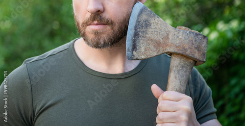 cropped photo of masculine guy with axe. masculine guy with axe. bearded masculine guy with axe.