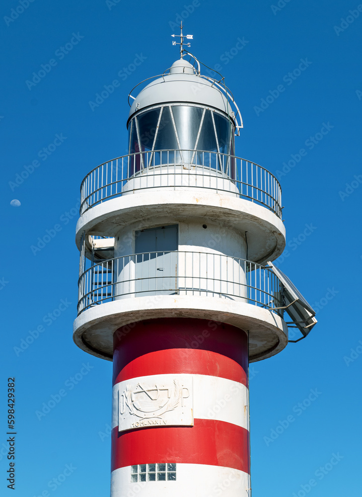 Lighthouse, against deep blue sky, with small moon. Location: Arinaga, Gran Canaria, Spain. Lighthouse, against deep blue sky, with small moon. Location: Arinaga, Gran Canaria, Spain.