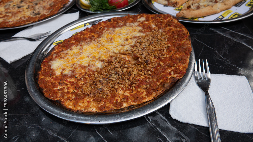 Mixed lahmacun with cheddar and roasted hazelnut. Mushroom and cheddar pita, traditional Turkish dish on the serving plate. Mixed lahmacun with cheddar and roasted hazelnut. Mushroom and cheddar pita, traditional Turkish dish on the serving plate.