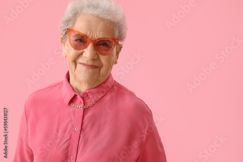 Senior woman on pink background, closeup