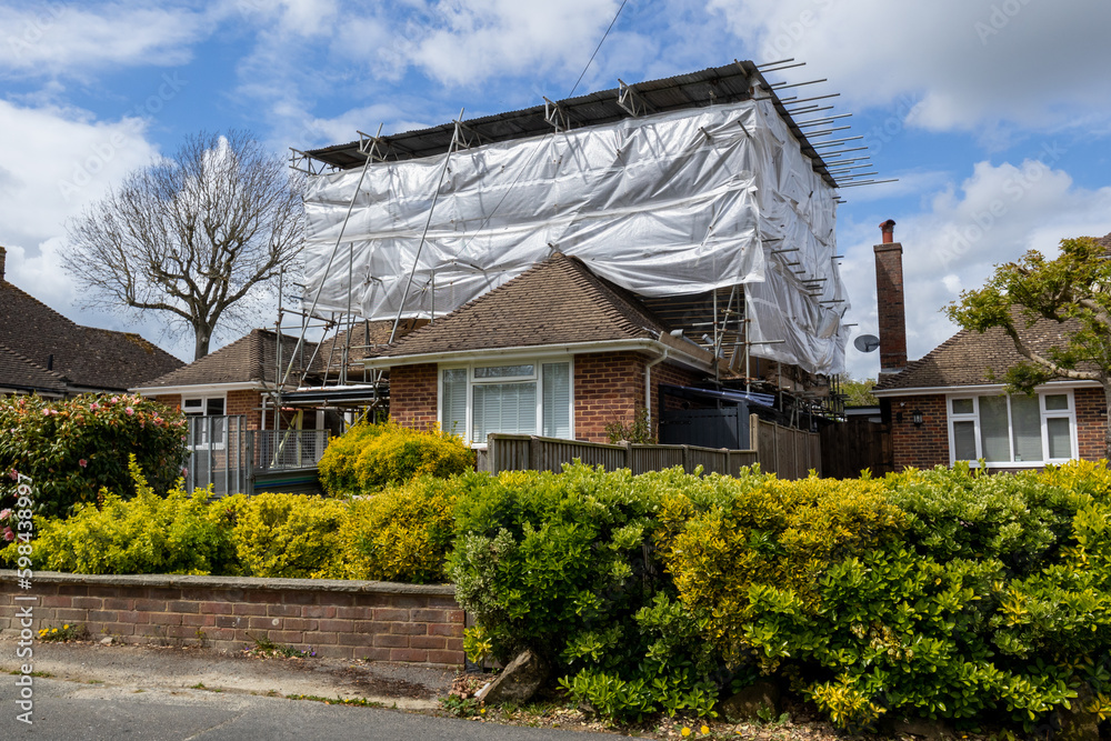Bungalow covered in tin hat scaffolding during building work to facilitate a loft conversion