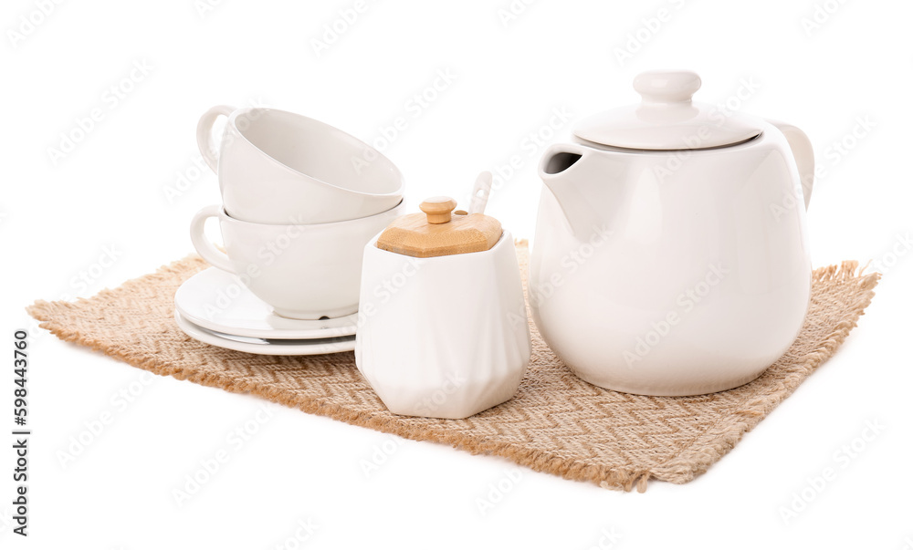 Fototapeta premium Wicker mat with teapot, sugar bowl and cups isolated on white background