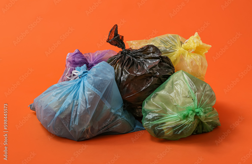 Full garbage bags on orange background Full garbage bags on orange background