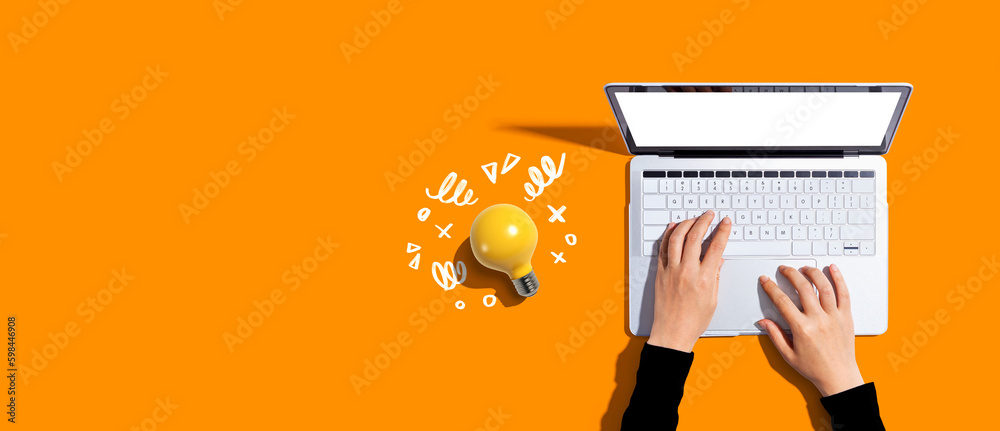 Person using a laptop computer and a light bulb - obrazy, fototapety, plakaty 