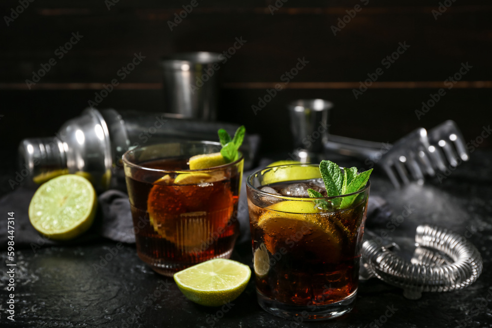 Glasses of tasty Cuba Libre cocktail on dark background Glasses of tasty Cuba Libre cocktail on dark background