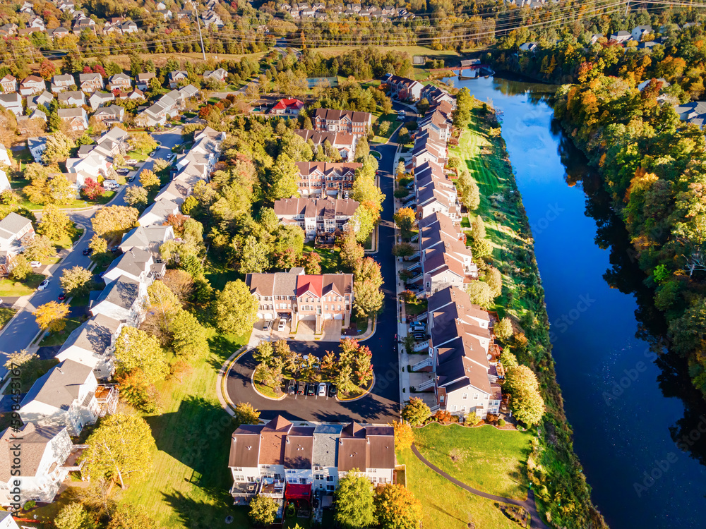 American suburb, view from above. Autumn landscape with colorful trees. Real estate, residential buildings of one-story America.