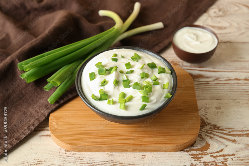 Composition with sour cream and sliced green onion on wooden table Composition with sour cream and sliced green onion on wooden table