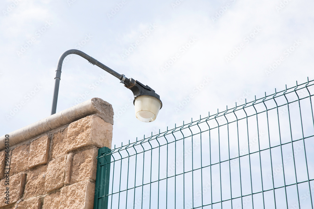 Obraz premium Lamp on a brick wall, illuminating a private area