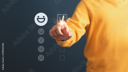 Client hand are touching the virtual screen on the happy smile face icon to give satisfaction in service. Opinion rating very impressed. Assessment testimonial customer service and feedback concept.