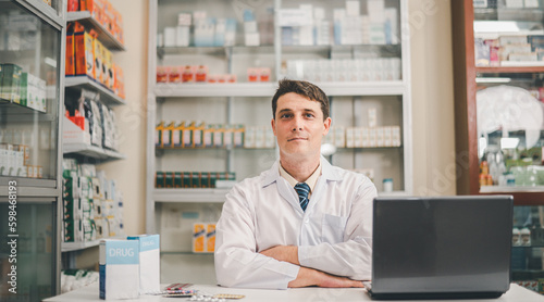 Male pharmacist posing confidently welcoming, advising patients and prescription patients in modern pharmacy.