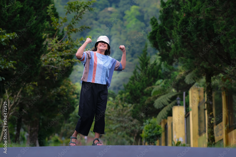 Asian middle aged woman walking in the morning around countryside Asian middle aged woman walking in the morning around countryside