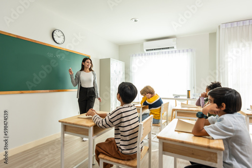 Group of student learn with teacher in classroom at elementary school. 