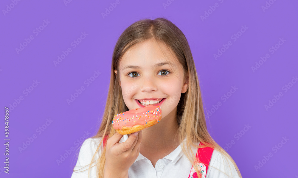 teen girl eating yummy donut isolated on purple. teen girl with yummy donut in studio