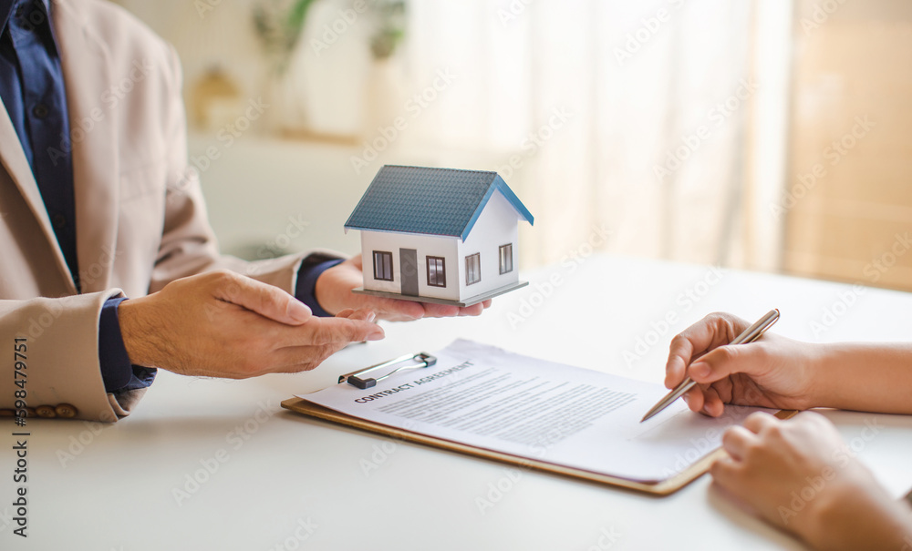 Fototapeta premium Real estate services for buying home holds house model and calculating table payment to customer.