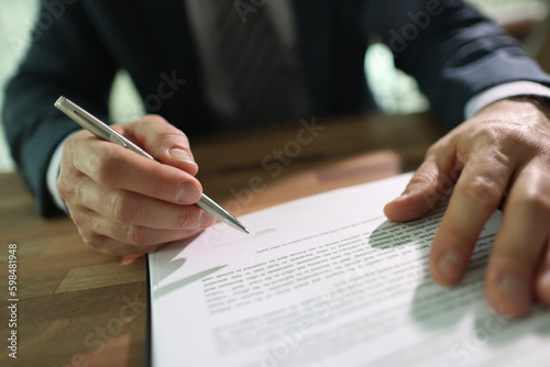 Businessman puts personal signature on contract paper sheet
