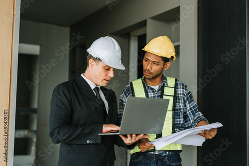 multi ethnic engineer brainstorming and measuring for cost estimating on blueprint and floor plan drawings about design architectural and engineering for houses and buildings