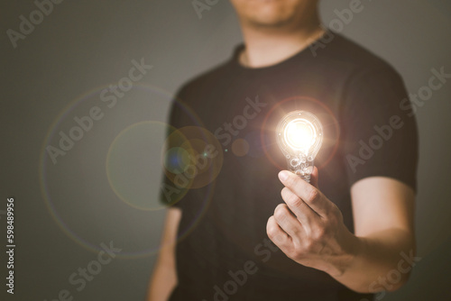 Man holds a light bulb in his hand with tech circles inside. The light emitted by the bulb, Idea inspired by online technology, Innovative concept.