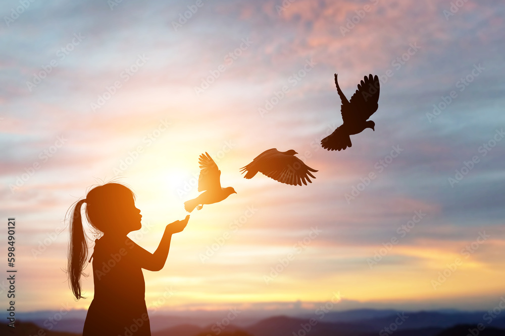 silhouette of bird flying out of Girl child hand on beautiful background.freedom concept ,International Working Women's Day - obrazy, fototapety, plakaty 