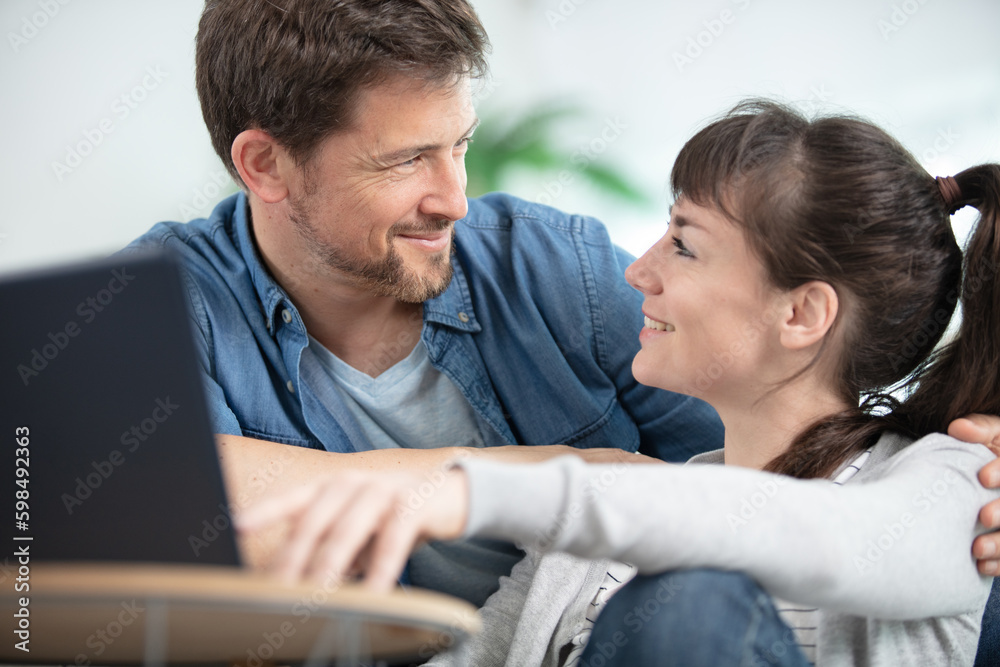 happy couple using laptop in their home happy couple using laptop in their home