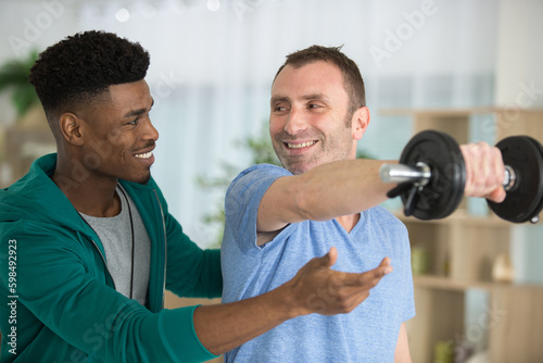 happy man receiving help by male physic therapist