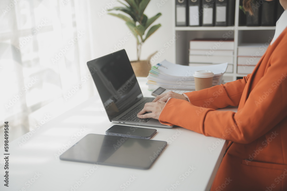 Attractive smiling young asian business woman work at home office, Asian woman working on laptop computer holding tablet. Attractive smiling young asian business woman work at home office, Asian woman working on laptop computer holding tablet.