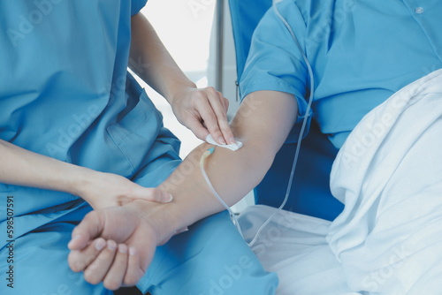 Injured patient showing doctor broken wrist and arm with bandage in hospital office or emergency room. Sprain, stress fracture or repetitive strain injury in hand. Nurse helping customer. First aid. © Sirikarn Rinruesee