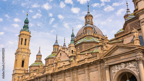 Domes with brightly colored tiles and Mudejar style towers of the basilica and cathedral of El Pilar, Zaragoza, Spain. © josemiguelsangar