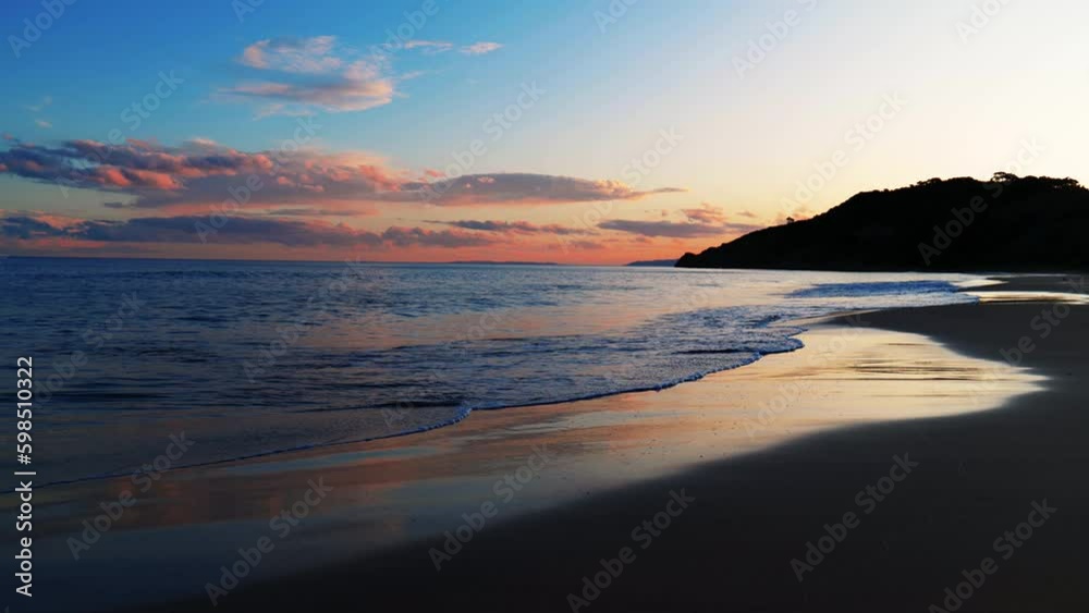Waves breaking on the shoreline at sunset. Makaorori Beach, Gisborne, New Zealand.