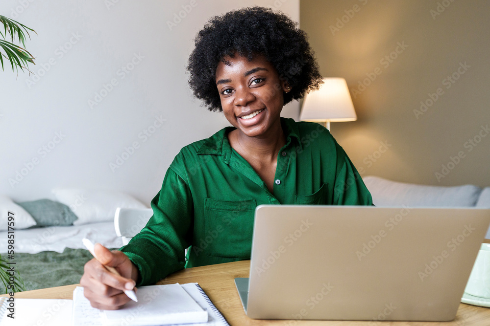 © Westend61 - Happy businesswoman with pen and laptop sitting at desk © Westend61 - Happy businesswoman with pen and laptop sitting at desk