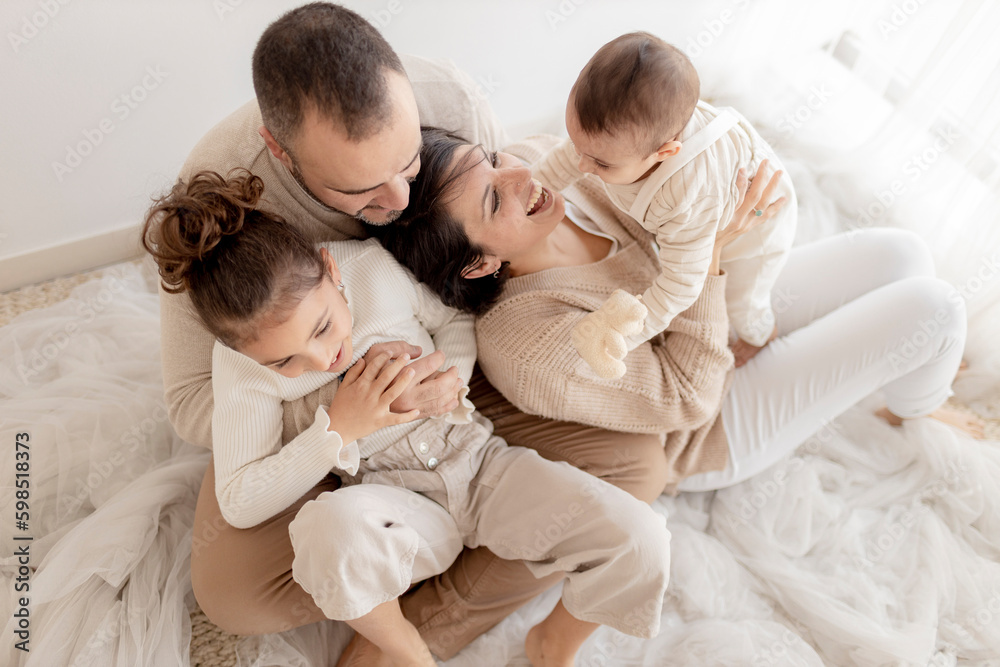 Father and mother enjoying with children sitting on floor Father and mother enjoying with children sitting on floor