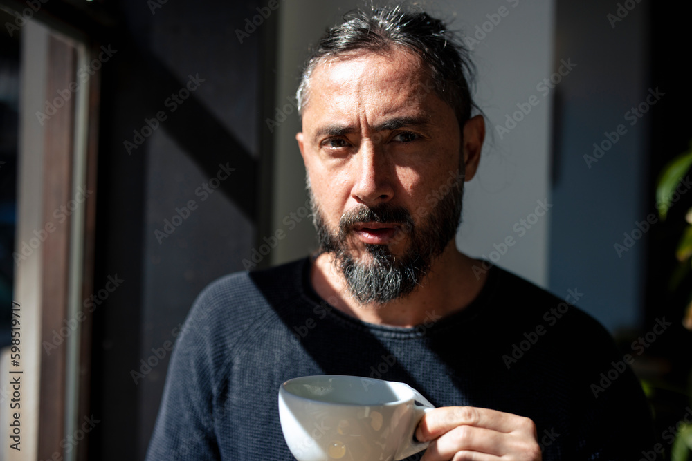 Mature man holding coffee cup in cafe at sunny day Mature man holding coffee cup in cafe at sunny day